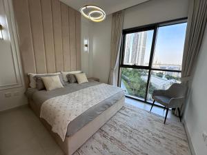 a bedroom with a bed and a large window at Creek Harbour retreat: Luxurious 2-BR apartment in Dubai