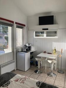 una pequeña cocina con mesa y microondas en La Coccinelle en Nimes