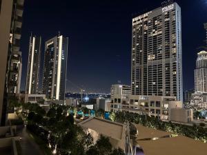 a view of a city at night with tall buildings at Creek Harbour retreat: Luxurious 2-BR apartment in Dubai