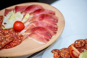 a cutting board with meat and vegetables on a table at Atera Business Suites in Belgrade