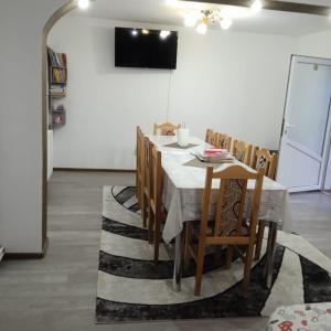 a dining room with a table and wooden chairs at Pensiunea Sara in Dâmbovicioara