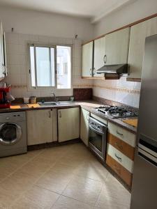 une cuisine avec un évier et une cuisinière four supérieur dans l'établissement Charmant appart 2 chamb+salon au cœur de la ville!, à Rabat