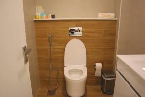 a small bathroom with a toilet with a hose at Amber Glow 2BR Apartment Al Raha in Abu Dhabi