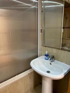 une salle de bain avec un lavabo, une douche et un miroir dans l'établissement Charmant appart 2 chamb+salon au cœur de la ville!, à Rabat