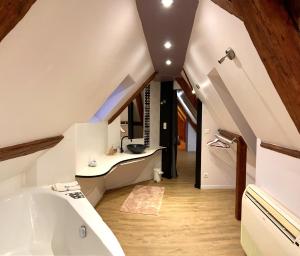 an attic bathroom with a tub and a sink at i-love-colmar - Le 8 de Coeur - Garage gratuit in Colmar
