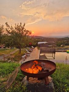 a fire pit on a dock with the sunset in the background at Fugger Alm in Weichselbaum