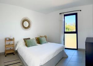 una camera da letto bianca con un letto e una finestra di Oasis Blue Perpignan Canet a Perpignano Altre 33 foto