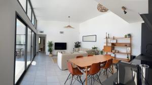 Oasis Blue Perpignan Canet في بيربينيا: غرفة معيشة مع طاولة وكراسي خشبية