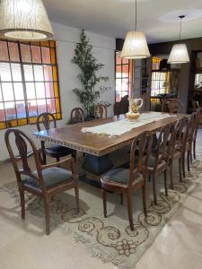 uma sala de jantar com uma mesa de madeira e cadeiras em Casa de Campo en LA GUAPEADA POLO, Pilar em Pilar