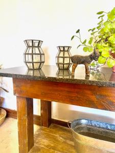 uma mesa com três vasos em cima em Casa de Campo en LA GUAPEADA POLO, Pilar em Pilar