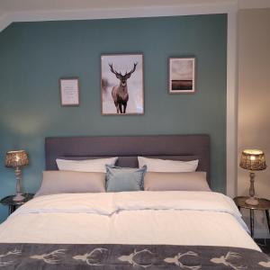 a bedroom with a bed with a deer on the wall at Skyline Luxus Suite Willingen in Willingen