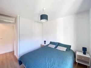 1 dormitorio con cama azul y almohadas azules en SEA VIEW Classé 3 étoiles climatisé Terrasse Vue Mer Parking by LaConciergerie13, en La Ciotat