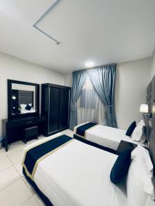 um quarto de hotel com duas camas e uma televisão em شقق عنوان المدينة للوحدات السكنية em Al Madinah