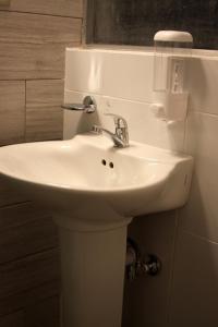 a white sink in a bathroom with a mirror at Super Precio in Guatemala