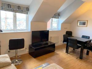 a living room with a table and a tv at Harbour Penthouse Whitby in Whitby