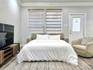 um quarto branco com uma cama e uma cadeira em King bed in gated community, 1300 sqft home em Houston