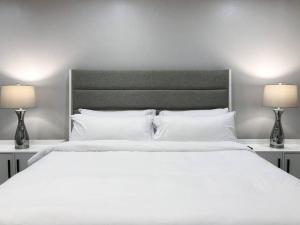 um quarto com uma grande cama branca e 2 candeeiros em King bed in gated community, 1300 sqft home em Houston
