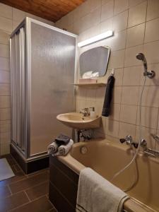 a bathroom with a tub and a sink and a shower at Almhof Grub in Wagrain +43 photos