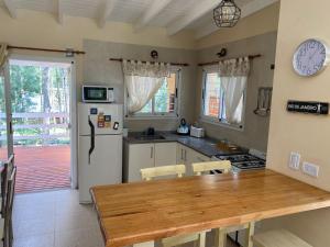 a kitchen with a table and a white refrigerator at Casa Libertad in Mar de las Pampas