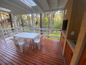 a porch with a white table and chairs on it at Casa Libertad in Mar de las Pampas +9 photos