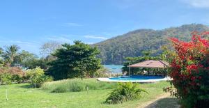 a garden with a gazebo and a lake at Casa Iguana in Las Tablas