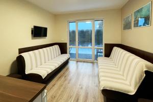 two white couches in a living room with a window at Marina Boszkowo in Boszkowo-Letnisko