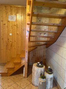 Habitación de madera con escaleras y 2 mesas. en Murań en Czarna Góra