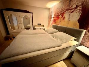 1 cama grande en una habitación con espejo en DIE FeWo Bleicherode zwischen Harz und Kyffhäuser en Wipperdorf