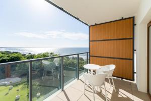 einen Balkon mit einem Tisch, Stühlen und Meerblick in der Unterkunft Aquamarina Prima Holiday Studios by the BEACH by Renters in Misdroy