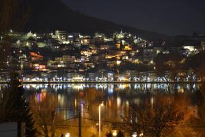 a view of a city at night with lights on the water at Stelios apartment in Kastoria