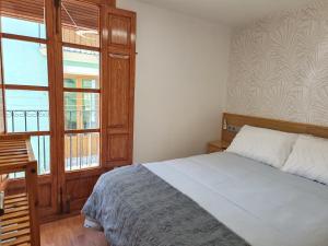 a bedroom with a bed and a large window at casa Mariana in Villajoyosa