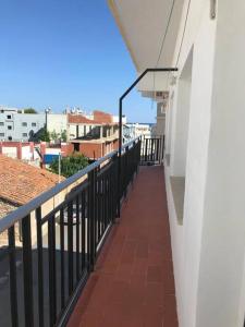 een balkon van een wit gebouw met een zwarte leuning bij Apartamento familiar a 200m de la playa in Alcossebre