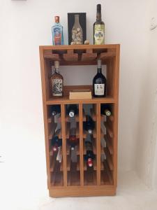 Gîte mziraa في Hammamet Sud: رف نبيذ خشبي عليه زجاجات نبيذ