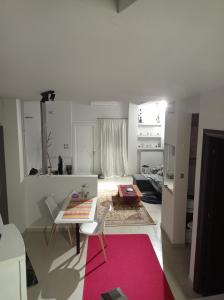 a living room with a table and a pink rug at Ioa Loft in Ioannina