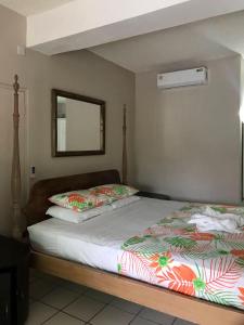 ein Bett mit zwei Kissen und einem Spiegel in einem Zimmer in der Unterkunft Bay Heights Escape in Gros Islet