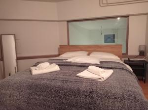 a bedroom with two white towels on a bed at Ioa Loft in Ioannina