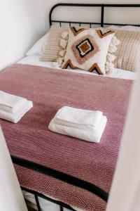 uma cama com duas toalhas brancas em cima em Apartament Pastelowy Kwidzyn em Kwidzyn