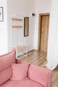 - un salon avec un canapé rose et une table dans l'établissement Apartament Pastelowy Kwidzyn, à Kwidzyn