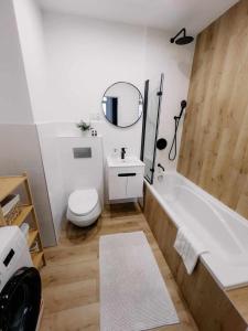 ein Badezimmer mit einer Badewanne, einem WC und einem Waschbecken in der Unterkunft Apartament Pastelowy Kwidzyn in Kwidzyn