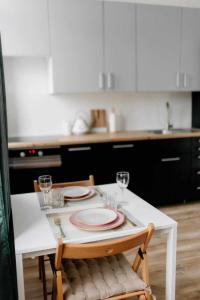 een keuken met een tafel met borden en glazen erop bij Apartament Pastelowy Kwidzyn in Kwidzyn