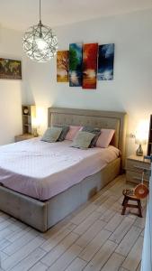 ポメツィアにあるPomezia centroのベッドルーム1室(壁に絵画が飾られた大型ベッド1台付)