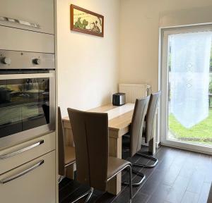 cocina con mesa de madera y sillas en near Düsseldorf Messe and Airport, two Bedrooms, Parking, Kitchen and Garden, en Duisburg