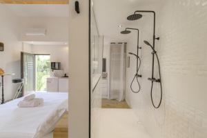 a white bedroom with a shower and a bed at Romantique et Sensuelle in Dardilly