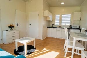 una cocina con armarios blancos y una mesa en una habitación en Holiday house for 4 people, pool, sauna, Ustronie, en Ustronie Morskie