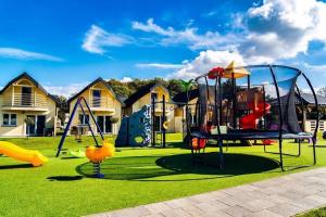 un parque con parque infantil con tobogán y columpios en Holiday house for 4 people, pool, sauna, Ustronie, en Ustronie Morskie