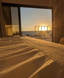 a bedroom with a bed with a view of the ocean at Al Saleh Chalet in Al Ashkharah