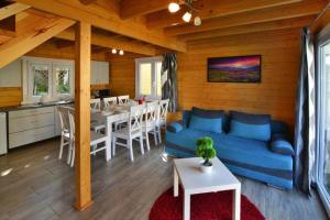 a living room with a blue couch and a kitchen at Holiday resort with Pool Whirlpool Sauna Ustronie Morskie in Ustronie Morskie