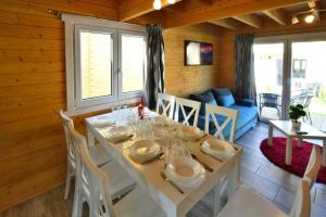 a dining room with a white table and chairs at Holiday resort with Pool Whirlpool Sauna Ustronie Morskie in Ustronie Morskie