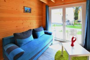 a blue couch in a room with a window at Holiday resort with Pool Whirlpool Sauna Ustronie Morskie in Ustronie Morskie