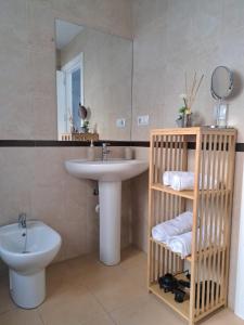 a bathroom with a sink and a toilet and a mirror at Atico TERRAZA DEL CARMEN in Salobreña